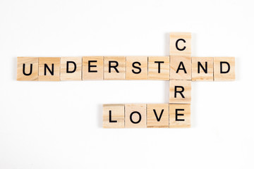 love,care and understand word written on wood block