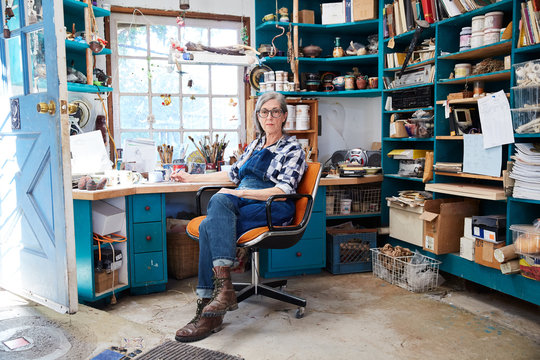 Portrait of senior woman with grey hair inside her pottery studio