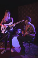 Confident man and woman performing with guitars 
