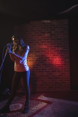 Confident female singer singing in popular music concert