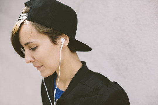 Profile of woman wearing baseball cap and headphones