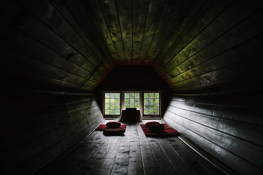 Beautiful, empty, wooden meditation room with small window looking towards trees