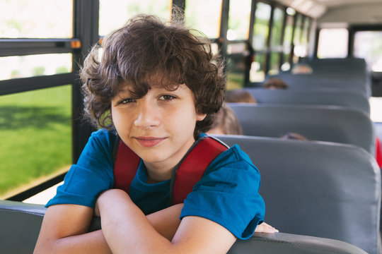 School Bus Boy With Curly Hair Looks Over Bus Seat