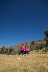 Group of women running through cones in the boot camp