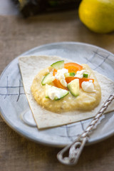 Delicious hummus on blue plate with the fresh vegetables.