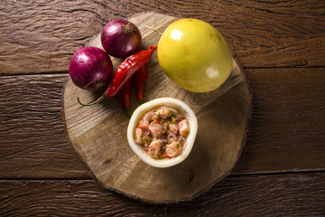 Salmon ceviche with passion fruit sauce on wooden background