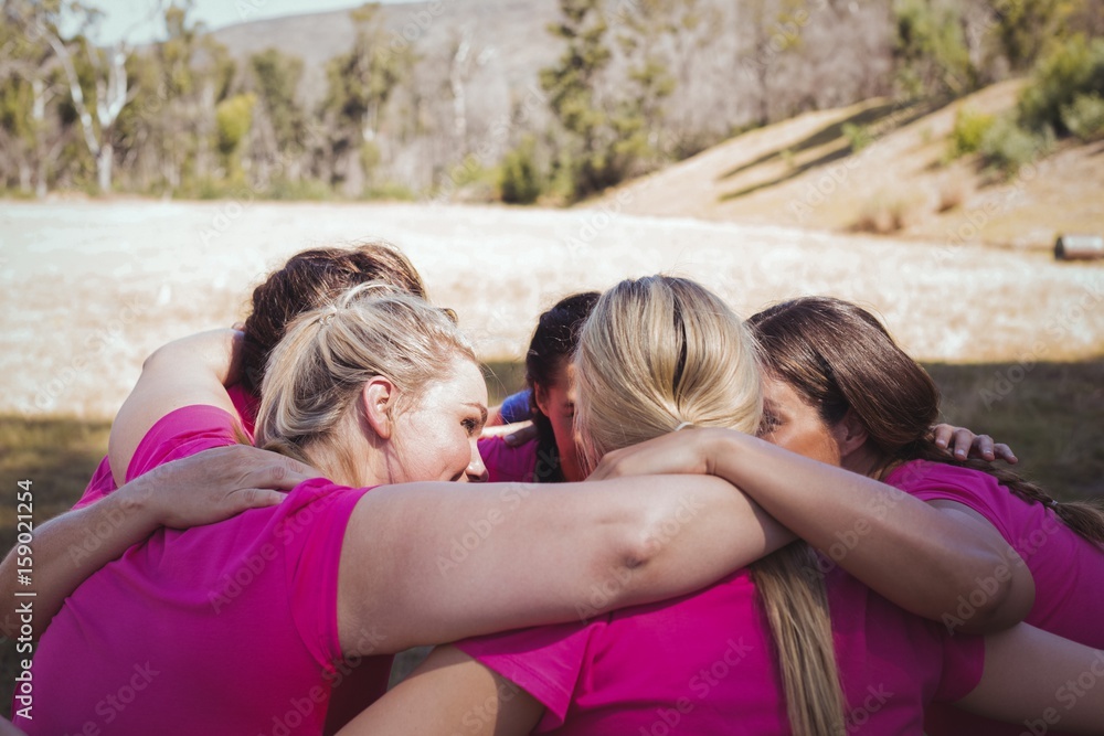 Wall mural Group of women forming huddles in the boot camp