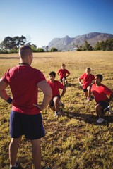 Trainer instructing kids while exercising in the boot camp