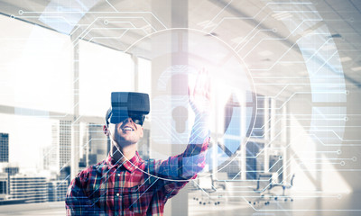 Young man in modern office interior experiencing virtual reality
