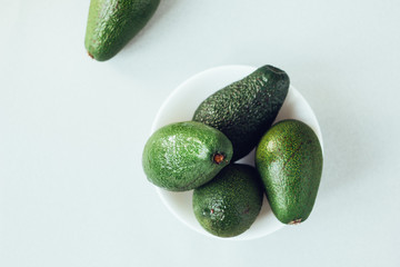 Fresh organic avocado in white ceramic bowl.