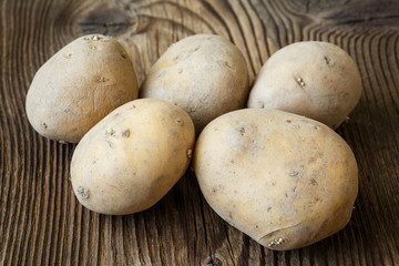 Fototapeta na wymiar Potatoes on wooden background.