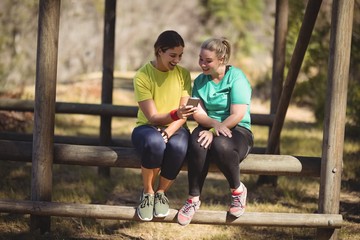 Happy friends using mobile phone in boot camp