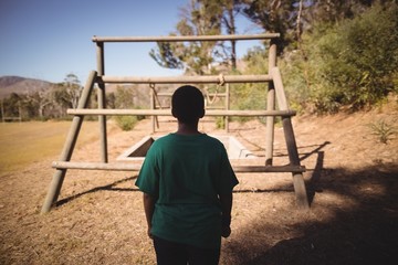 Rear view of boy looking at outdoor equipment 
