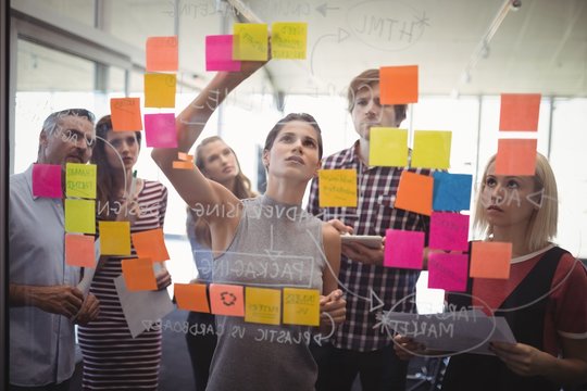 Business people planning with adhesive notes in creative office