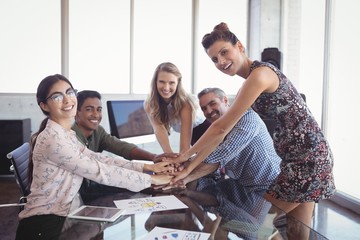 Portrait of smiling business people stacking hands 