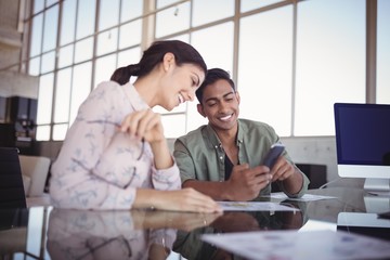 Smiling businessman sitting with female colleague 