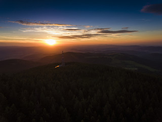 Sunset. Aerial view of the summer time in mountains near Czarna Gora mountain in Poland. Pine tree forest and clouds over blue sky. View from above.