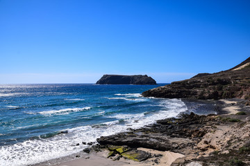 Over looking the small cove of Calhau da Serra de Fora with Ilheu de Cima on the horizon Porto Santo, Madeira
