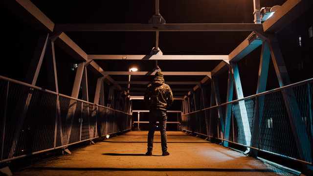 Backside view of a man standing on the bridge