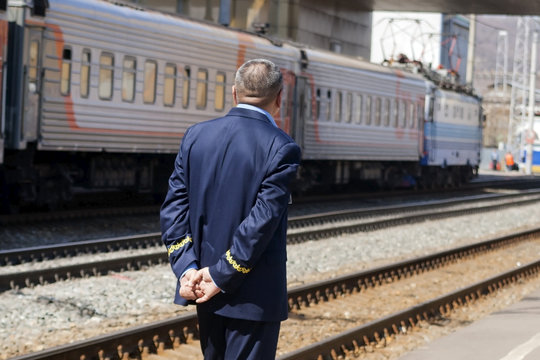 The train conductor awaits his arrival on the platform