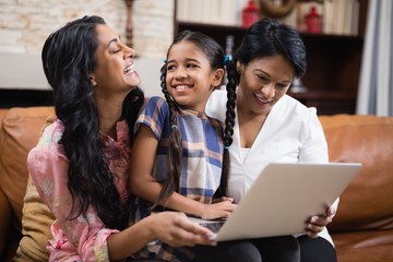 Happy family using laptop while sitting together