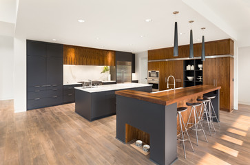 Beautiful Kitchen Interior in New Luxury Home. Boasts Two Islands, Two Sinks, Stainless Steel Appliances, and Stunning Hardwood Cabinets and Countertop