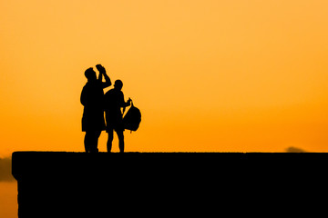 Fototapeta na wymiar Tourists trying to catch the sundown. Near the Maspalomas Lighthouse in the south of Gran Canaria