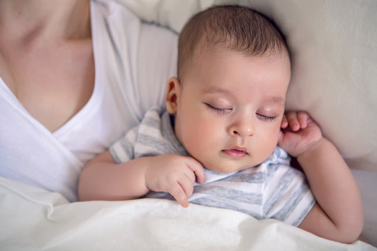baby sleeps next to mom in the big parental bed