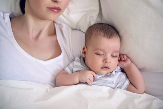 baby sleeps next to mom in the big parental bed
