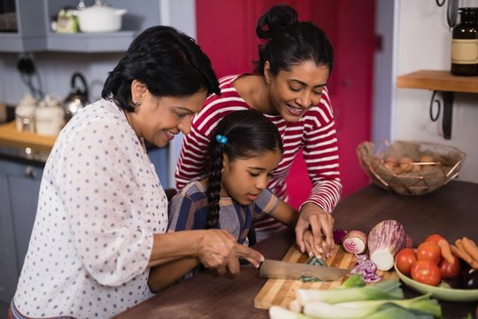 Multi-generation family preparing food together in kitchen