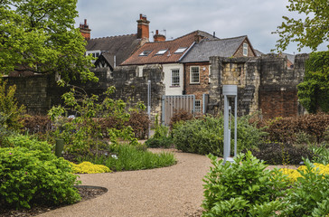 York, England.  Public Park and formal garden setting with shrubs, trees, plants and houses in the background.  Overcast sky in the background