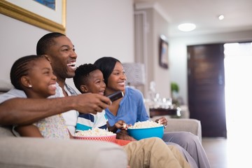 Cheerful african american family having popcorn while watching television