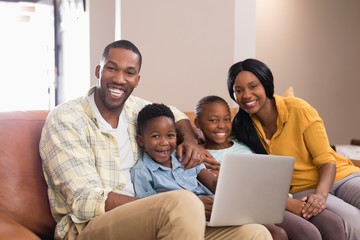 Portrait of parents and children holding laptop 