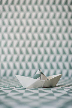 Origami boat on wallpaper background