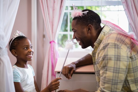 Happy Father And Daughter Wearing Costume At Home