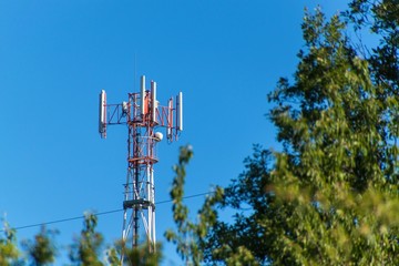Technology on the top of the telecommunication GSM. Masts for mobile phone signal. Tower with antennas of cellular communication on the background of blue sky.