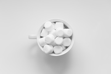 White marshmallows in a white cup on white background, from above