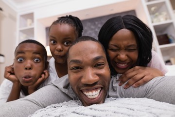 Portrait of happy family lying on bed