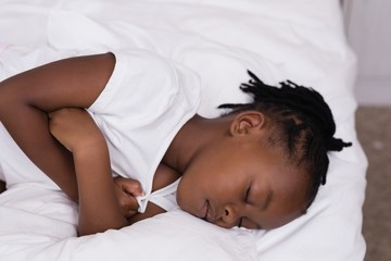 High angle view of girl sleeping on bed