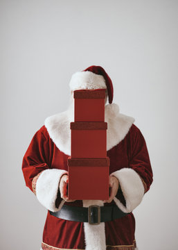 Santa Claus Behind Stack Of Fancy Red Gifts