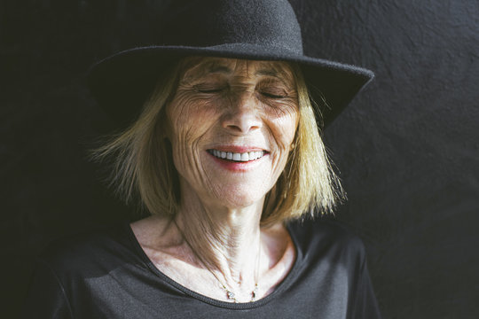 Portrait of smiling senior woman with a black hat