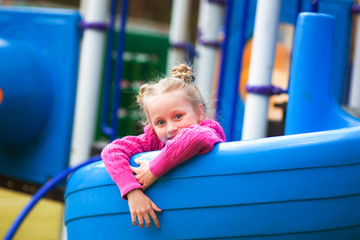 Fototapeta na wymiar Cute little girl having fun on a playground outdoors in summer