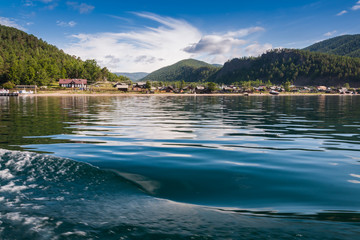 lake Baykal near green forest mountain and wooden house © kuzenkova