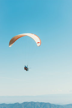 man practicing paragliding on the mountains