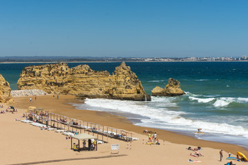 Fototapeta na wymiar Very beautiful portugese beach with rocks, aquamarine sea and dark yellow sand