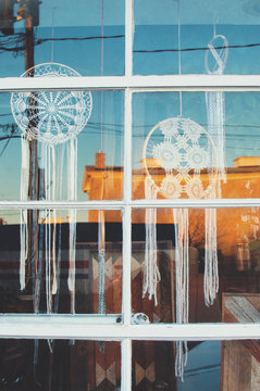 Dreamcatchers through a window of a small town at susnet