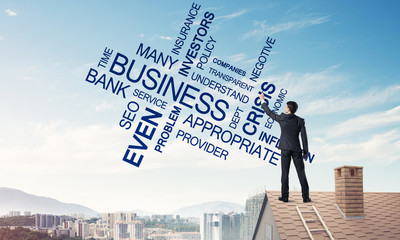 Young businessman standing on house roof and writing leadership 