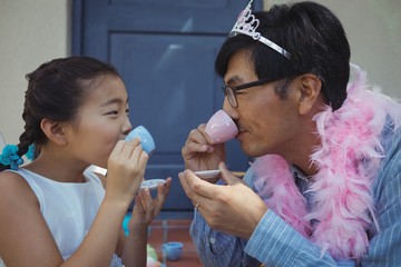 Father and daughter in fairy costume having a tea party
