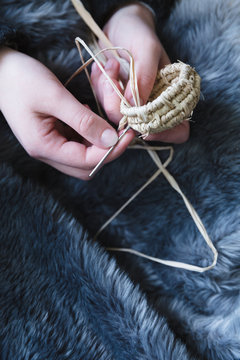 Girls hands making small raffia basket - vertical