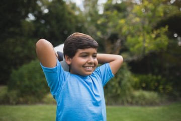 Smiling boy holding soccer ball at park